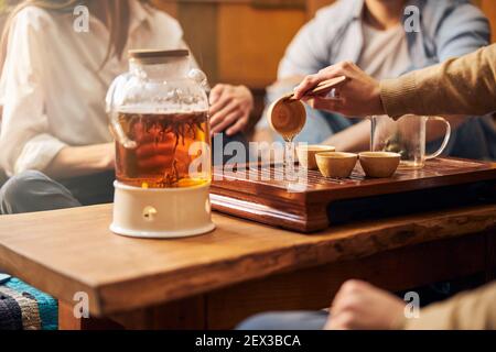 Junger Mann, der traditionelle Teezeremonie im Café durchführt Stockfoto