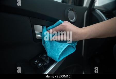 Nahaufnahme der Hand einer Person, die den Türgriff eines Autos reinigt, um ihn zu desinfizieren. Prävention von Covid 19 oder Coronavirus. Stockfoto