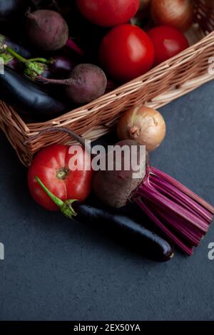 Gemüskorb. Frisches Gemüse auf dem Tisch schwarzer Hintergrund. Set mit Verpackung für die Lebensmittelzustellung. Brokkoli, Kohl, Auberginen, Weißkohl, Gurken, Dill, Blumenkohl. Stilllife Draufsicht Stockfoto