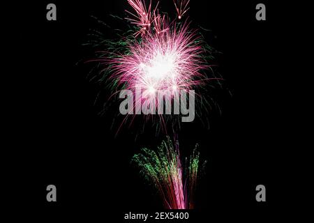 Image with a black background prepared to edit text of a firework, formed by a star with lilac and green traces, as well as another artificial fire wi Stockfoto