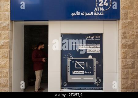 Ein palästinensischer Mann, der Geldautomat in Geldautomaten benutzt Der Nationalbank (TNB) in der Stadt Rawabi Im Westufer Stockfoto