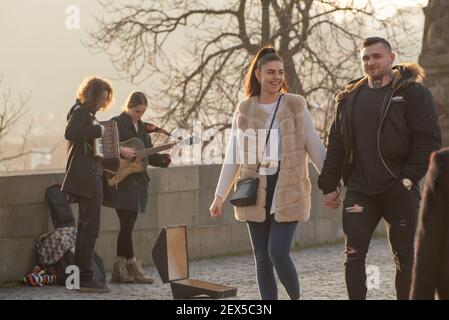 Prag, Tschechische Republik. 03-02-2021. Das junge Paar läuft, redet, lächelt und hat viel Spaß auf der Karlsbrücke im Stadtzentrum von Prag d Stockfoto