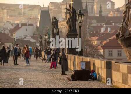 Prag, Tschechische Republik. 03-02-2021. Bettler, der im Winter auf der Karlsbrücke im Stadtzentrum von Prag um Geld bat. Stockfoto