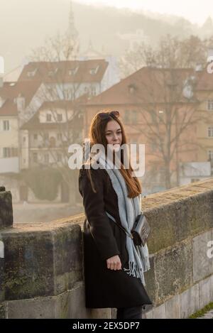 Prag, Tschechische Republik. 03-02-2021. Eine schöne, attraktive und stilvolle junge Frau auf der Karlsbrücke im Stadtzentrum von Prag im Winter w Stockfoto