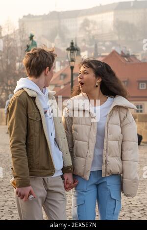 Prag, Tschechische Republik. 03-02-2021. Junges Paar Spaß auf der Karlsbrücke in der Innenstadt von Prag im Winter mit einem schönen Sonnenuntergang. Stockfoto