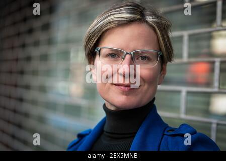 Porträt einer attraktiven dreißig Jahre alten weißen Frau posiert In einer traditionellen engen Straße Stockfoto