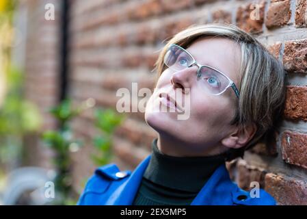 Porträt einer attraktiven dreißig Jahre alten weißen Frau posiert In einer traditionellen engen Straße Stockfoto