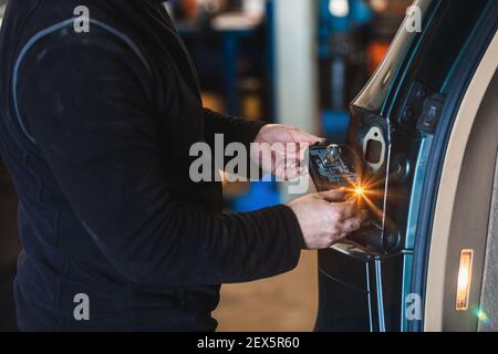Mechaniker reparieren Auto Rücklicht. Elektromechanische Werkstatt. Arbeiten mit seinen Händen. Werkzeuge. Konzept der Auto-Reparatur Stockfoto