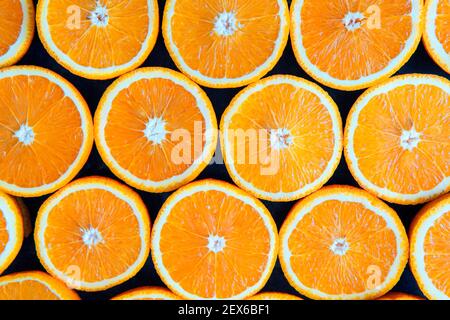 Orangen oder Grapefruits werden auf schwarzem Hintergrund halbiert. Nahaufnahme Makro Stockfoto