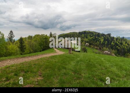 Filipka in Slezske Beskydy Berge in Tschechien mit wenigen isolierten Haus, Wiese und Loucka Hügel im Hintergrund im Frühling Stockfoto