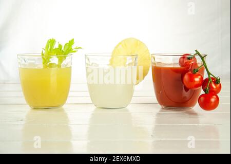 Drei Gläser mit 3 verschiedenen Säften: Tomaten, Ananas und Sellerie Stockfoto