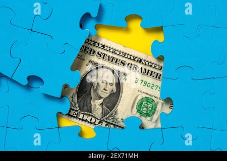 US-Dollar-Banknote versteckt unter Puzzle Finanzkonzept Stockfoto