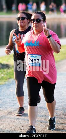 North Babylon, New York, USA - 8. Juli 2019: Eine Läuferin gibt das Friedenszeichen mit beiden Händen beim Rennen um Belmont Lake State Par 5K Stockfoto