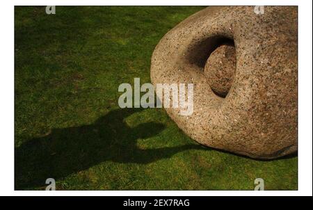 18 Tonnen Granit-Gletscherfelsen und Bronzekunst, vom britischen Bildhauer Peter Randall-Page, wurden an den Westrasen des Natural History Museums geliefert. Die Ausstellung markiert den Beginn des Frühlings. 'Stone Bearing Stone' mit Schatten des Künstlers.pic David Sandison 27/3/2003 Stockfoto