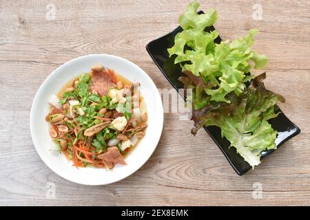 Knuspriger Fisch mit Schweinefleisch paar Maw Topping Erdnuss in würzigen Und saure Chilisauce Salat auf dem Teller Stockfoto