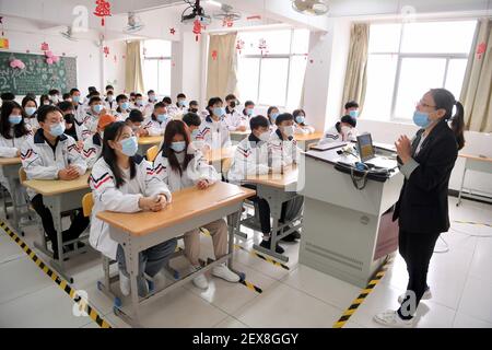 (210304) -- FUZHOU, 4. März 2021 (Xinhua) -- EIN Lehrer spricht mit Schülern aus der Autonomen Region Ningxia Hui im Nordwesten Chinas an der SCUD Senior Technical School in Fuzhou, südöstlich der Provinz Fujian in China, 4. März 2021. Seit 2018 kommen 459 junge Menschen aus verarmten Familien in Ningxia zur Fujian SCUD Senior Technical School, um ihre Fähigkeiten zu erlernen. Nach dem Abschluss werden sie in SCUD Elektronik-Unternehmen zu SCUD Group Limited verbunden arbeiten. In den letzten Jahren sind Gruppen von jungen Menschen aus Ningxia durch Trainingsprogramme nach Fujian gekommen, um mehr Fähigkeiten zu erlernen. (Xinhua/Jiang Kehong) Stockfoto