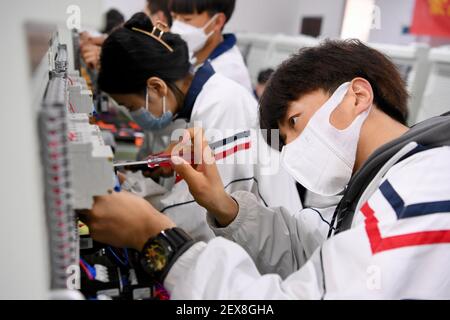 (210304) -- FUZHOU, 4. März 2021 (Xinhua) -- Schüler aus der Autonomen Region Ningxia Hui im Nordwesten Chinas besuchen Kurse an DER SCUD Senior Technical School in Fuzhou, südöstliche Provinz Fujian, 4. März 2021. Seit 2018 kommen 459 junge Menschen aus verarmten Familien in Ningxia zur Fujian SCUD Senior Technical School, um ihre Fähigkeiten zu erlernen. Nach dem Abschluss werden sie in SCUD Elektronik-Unternehmen zu SCUD Group Limited verbunden arbeiten. In den letzten Jahren sind Gruppen von jungen Menschen aus Ningxia durch Trainingsprogramme nach Fujian gekommen, um mehr Fähigkeiten zu erlernen. (Xinhua/Jiang Kehong) Stockfoto