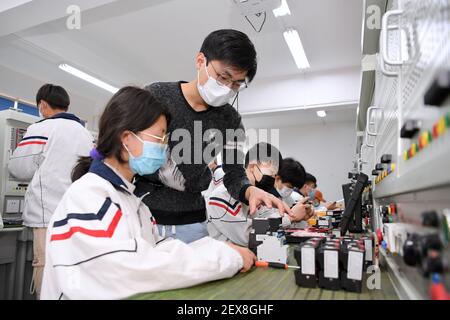 (210304) -- FUZHOU, 4. März 2021 (Xinhua) -- EIN Lehrer führt Schüler aus der Autonomen Region Ningxia Hui im Nordwesten Chinas an der SCUD Senior Technical School in Fuzhou, südöstlich der Provinz Fujian in China, 4. März 2021. Seit 2018 kommen 459 junge Menschen aus verarmten Familien in Ningxia zur Fujian SCUD Senior Technical School, um ihre Fähigkeiten zu erlernen. Nach dem Abschluss werden sie in SCUD Elektronik-Unternehmen zu SCUD Group Limited verbunden arbeiten. In den letzten Jahren sind Gruppen von jungen Menschen aus Ningxia durch Trainingsprogramme nach Fujian gekommen, um mehr Fähigkeiten zu erlernen. (Xinhua/Jiang Kehong) Stockfoto