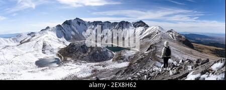Frauen Bergwanderweg mit Schnee bedeckt tragen eine weiße Daunenjacke. Panorama des Vulkans Nevada de Toluca mit Seen im Krater in Mexiko Stockfoto