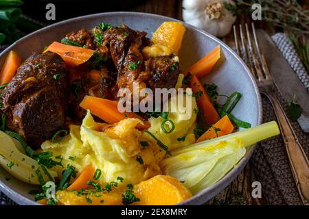 Geschmorte Rinderschenkel mit Fenchel und Karottengemüse in Orangensaft gekocht und mit Orangenstückchen, Kartoffelpüree und köstlicher Sauce serviert Stockfoto