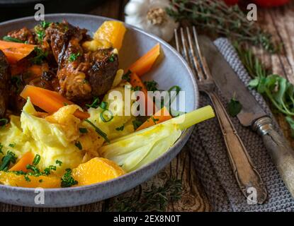 Köstliche Gemüsebeilage mit, Fenchel, Karotten in Orangensaft gekocht und serviert mit Orangen und Kartoffelpüree auf einem Teller mit Fleisch Stockfoto