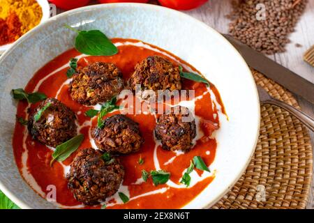 Veganes Gericht mit orientalischer Tomatensuppe und Linsennüssen-Fleischbällchen Stockfoto