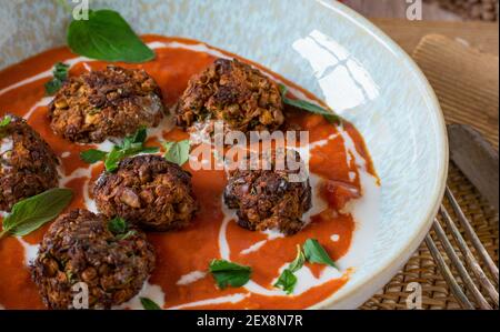 Veganes Fleischgericht mit Linsennussfleischbällchen und Tomatensauce Serviert auf einem Teller Stockfoto