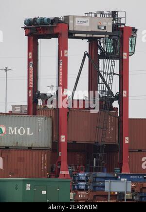 Ein Straddle Carrier bewegt einen Container in die Lagerdockside am DP World Containerterminal im Hafen von Southampton. Bilddatum: Donnerstag, 4. März 2021. Stockfoto