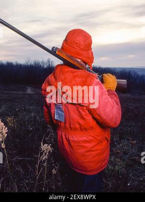 SYRACUSE, NEW YORK, USA - Jäger mit roter Jacke, Lizenz und Schusswaffe im Bundesstaat New York. Stockfoto