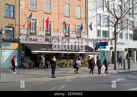 DUBLIN, IRLAND - Mär 05, 2020: Die Menschen warten auf die grüne Ampel an der Fußgängerüberfahrt im Stadtzentrum von Dublin. The Murray's Bar and Grill in Th Stockfoto