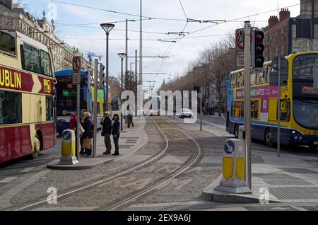 DUBLIN, IRLAND - 05. März 2020: Verkehr an der O'Connell Street in Dublin. Eintreffende Luas Straßenbahn in der Mitte. Die Leute warten an der Ampel. Dublin Bus Stockfoto