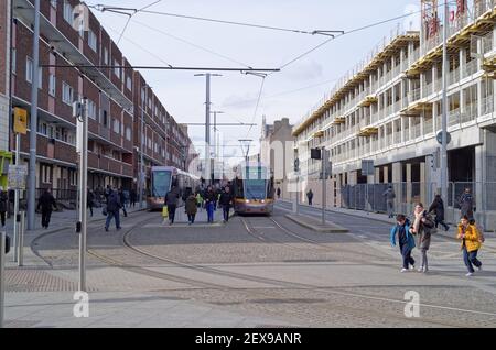 DUBLIN, IRLAND - Mär 05, 2020: Blick auf die Straße im Stadtzentrum von Dublin mit Luas Straßenbahnen an der Haltestelle und Menschen zu Fuß. Neue Baustelle auf der Stockfoto