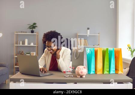 Inspirierte afroamerikanische Frau Kauf online treffen Entscheidungen auf Laptop Stockfoto