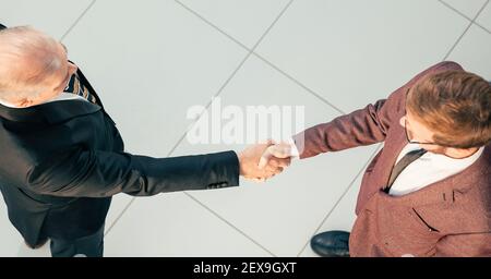 Draufsicht. Seriöse Geschäftspartner, die sich die Hände schütteln. Stockfoto