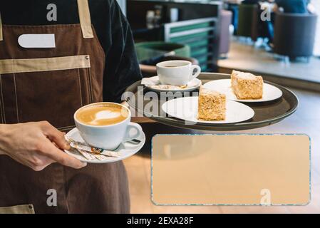 Kellner mit einem Tablett in einer Hand, einem Glas Kaffee und zwei Portionen Kuchen Stockfoto