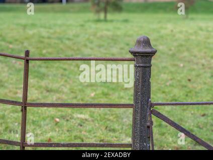 Ein Metallgußeisen Pfosten und Zaun mit Dekoration und Rost. Stockfoto