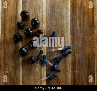 Eine Sammlung von Amber Dropper Flaschen auf einem Holzhintergrund Stockfoto