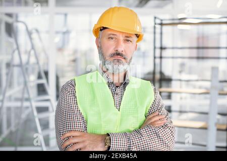 Portrait von reifen Architekten in Helm posiert drinnen Stockfoto