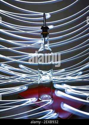 Kleine schmale Flasche mit Barkeeper Pourer auf Tisch mit Licht Herumpausen Stockfoto