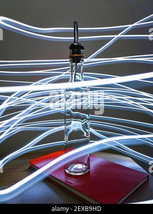 Kleine schmale Flasche mit Barkeeper Pourer auf Tisch mit Licht Herumpausen Stockfoto