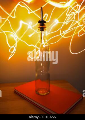 Kleine schmale Flasche mit Barkeeper Pourer auf Tisch mit Licht Herumpausen Stockfoto