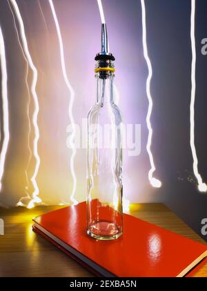 Kleine schmale Flasche mit Barkeeper Pourer auf Tisch mit Licht Herumpausen Stockfoto