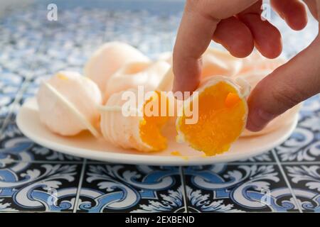 Hand nehmen eine traditionelle portugiesische süß namens Ovos Moles de Aveiro Stockfoto