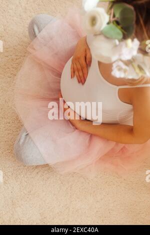 Schwangere Frau bleiben im Zimmer und schauen Sie sich die an Bauch Stockfoto