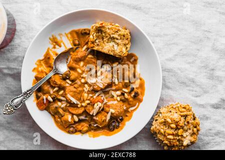 Rote Pfeffer & Würstensuppe in einer weißen Schüssel mit Zucchini-Muffins Stockfoto