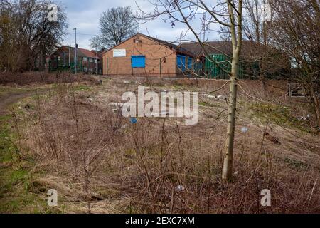 Fliegen kippte Müll und Hausmüll illegal auf die gedumpt Rand des lokalen Waldes in Großbritannien.EIN geschlossenes SureStart Center Kann im Hintergrund gesehen werden Stockfoto