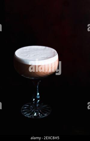 Pink Gin Sour Drink in einem Coupé-Glas mit gekrönt Weißer Eierschaum Stockfoto