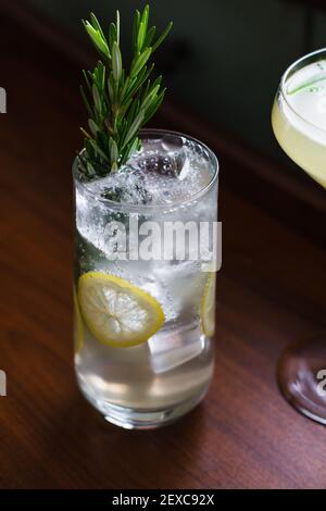 Eisiger und sprudelnder Gin Drink, garniert mit Zitronenscheiben und Rosmarin Stockfoto