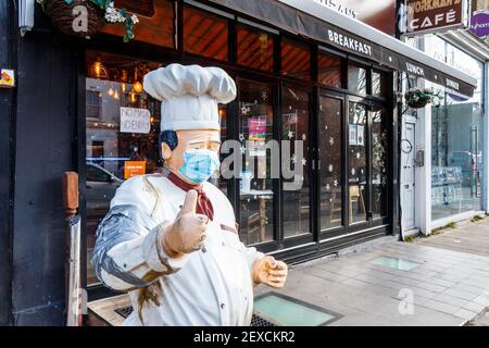 Eine Chef-Mannequin mit Maske signalisiert vor einem Café in Islington, das während der dritten Coronavirus-Sperre, London, Großbritannien, zum Mitnehmen geöffnet ist, einen 'Daumen nach oben' Stockfoto