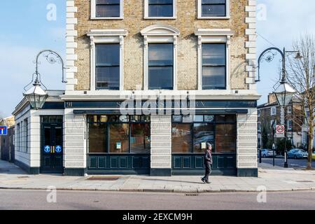 Ein Mann geht an der St. John's Tavern vorbei, einem beliebten Pub in Archway, Islington, während der dritten Coronavirus-Sperre, London, Großbritannien Stockfoto